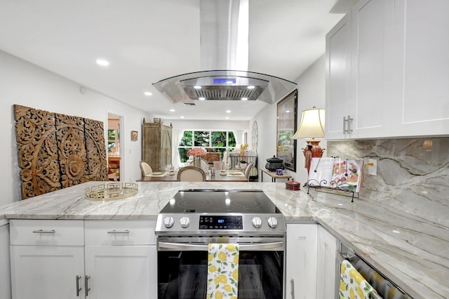 kitchen with island exhaust hood, electric range, light stone counters, and white cabinets