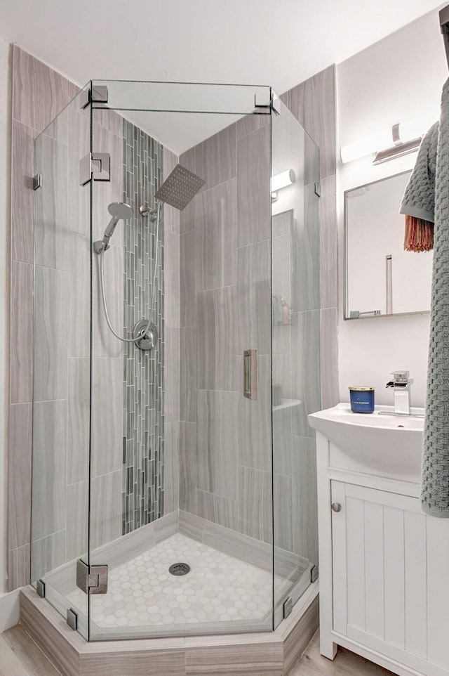 bathroom with vanity, a shower with shower door, and hardwood / wood-style floors