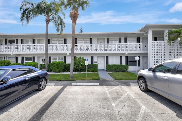 view of front of property featuring a balcony and a front yard