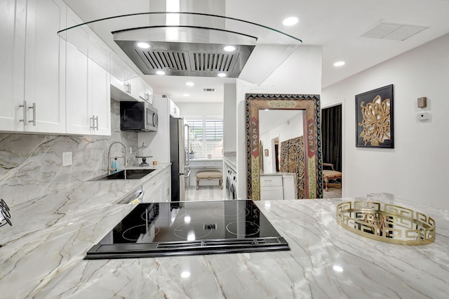 kitchen featuring white cabinetry, light stone counters, stainless steel appliances, and sink