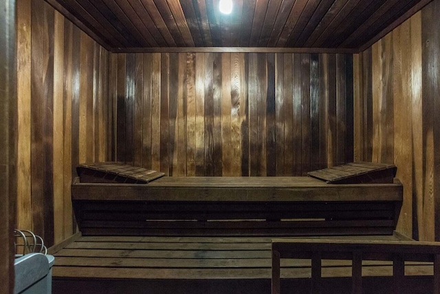 view of sauna featuring wood ceiling and wood walls