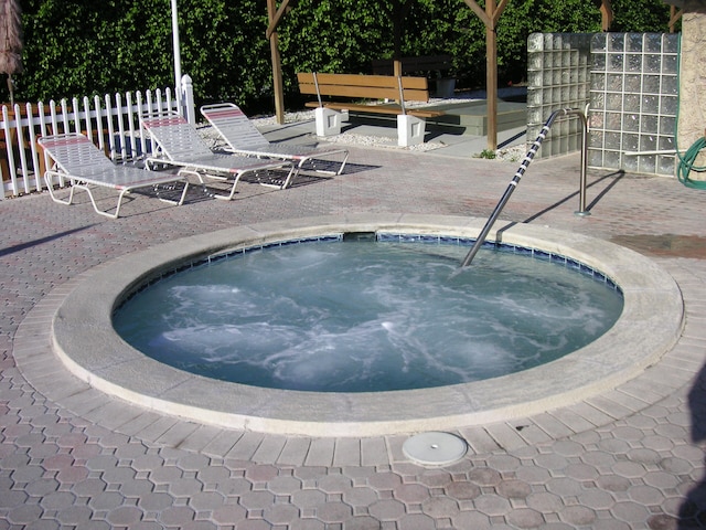 view of swimming pool featuring a hot tub and a patio area