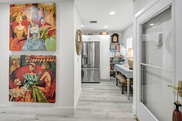 interior space featuring white cabinetry, light wood-type flooring, and stainless steel fridge with ice dispenser