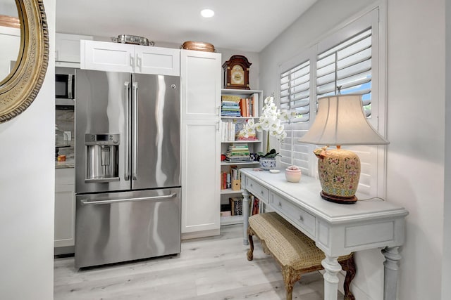 kitchen featuring white cabinets, stainless steel appliances, and light wood-type flooring