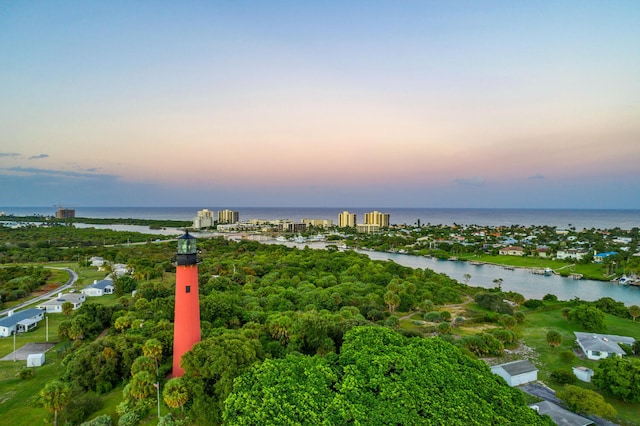 aerial view at dusk featuring a water view