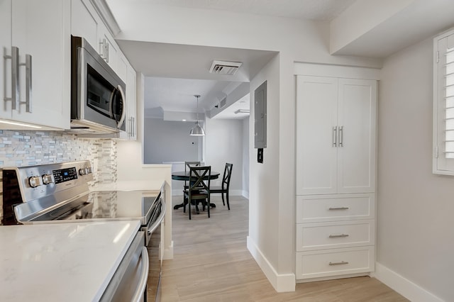 kitchen featuring appliances with stainless steel finishes, tasteful backsplash, white cabinets, and light wood-type flooring