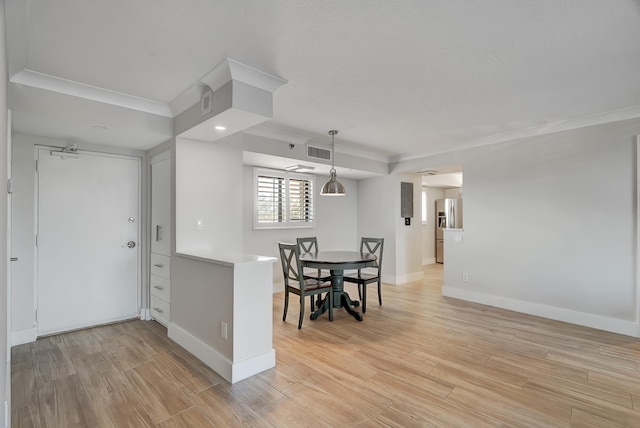 dining area featuring light hardwood / wood-style flooring and crown molding