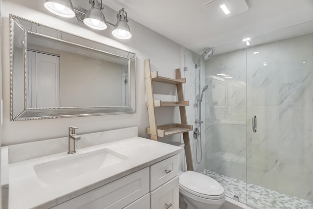 bathroom featuring vanity, a shower with shower door, and toilet