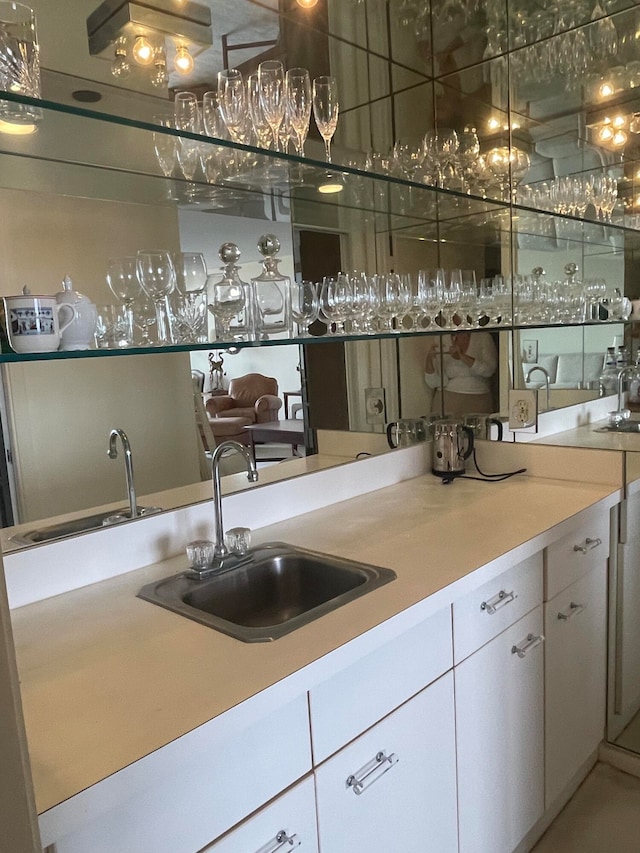 bar featuring white cabinets and sink