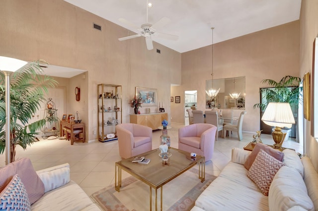 living room with light tile patterned floors, ceiling fan with notable chandelier, and a high ceiling