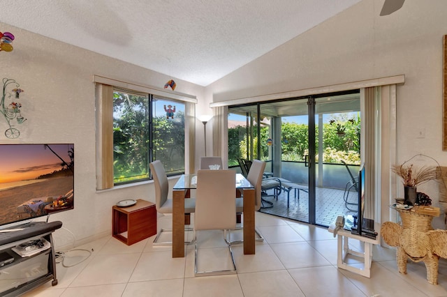 tiled dining room with lofted ceiling and a textured ceiling