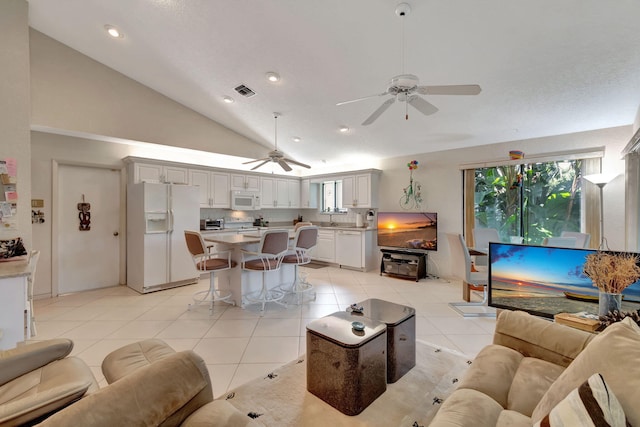 tiled living room with sink and high vaulted ceiling