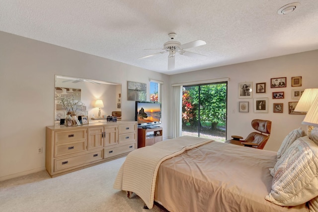 bedroom featuring ceiling fan, access to exterior, light carpet, and a textured ceiling