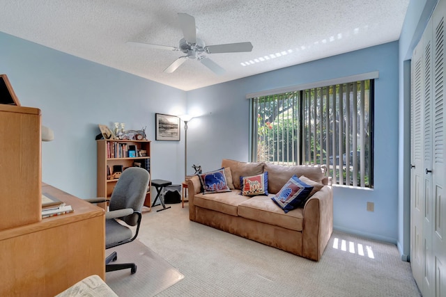 office featuring ceiling fan, light carpet, and a textured ceiling