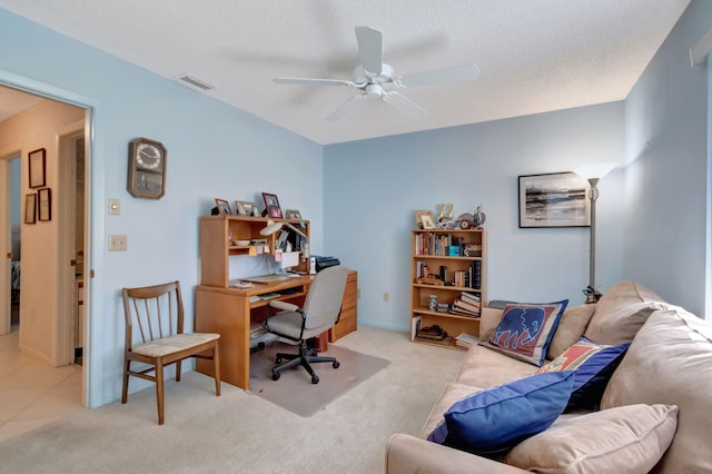 office space with light carpet, a textured ceiling, and ceiling fan