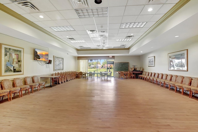 interior space with a drop ceiling, a tray ceiling, and wood-type flooring