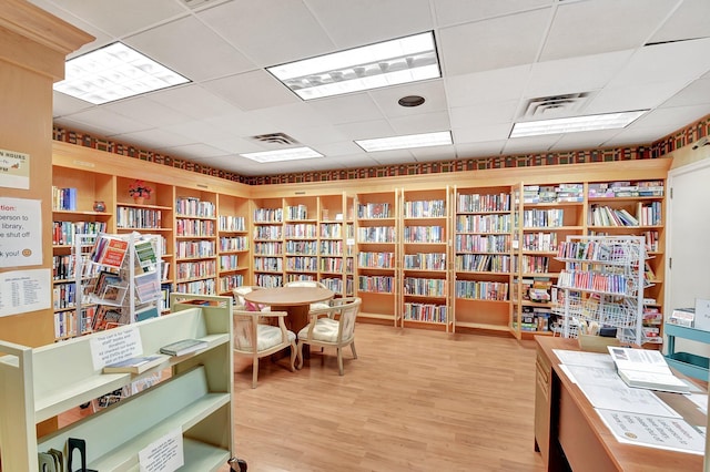 interior space with hardwood / wood-style floors and a drop ceiling