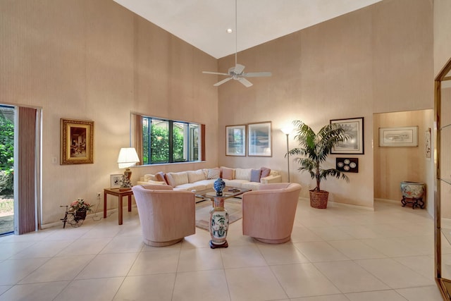 tiled living room featuring ceiling fan and a towering ceiling