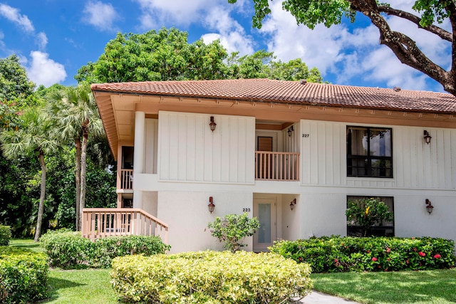 view of front of home featuring a balcony and a front yard