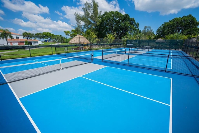 view of tennis court with basketball hoop