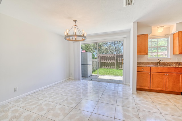 unfurnished dining area with sink, light tile patterned floors, and plenty of natural light