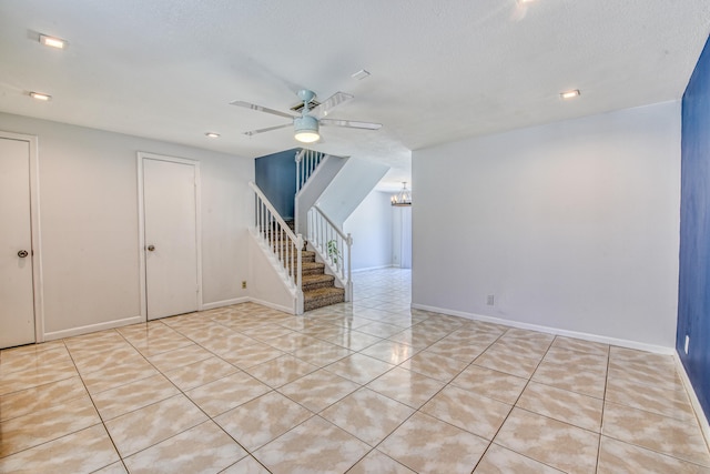 interior space with a textured ceiling, light tile patterned floors, and ceiling fan