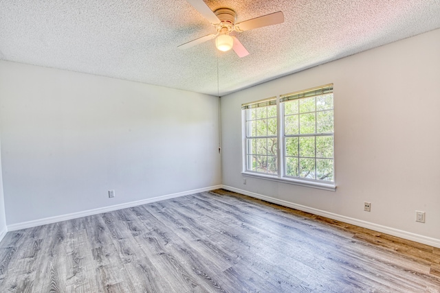 empty room featuring a textured ceiling, ceiling fan, and wood-type flooring