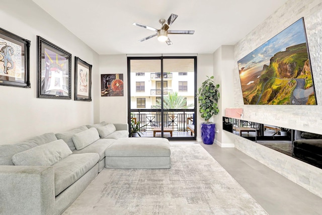 living room featuring floor to ceiling windows, ceiling fan, and concrete floors