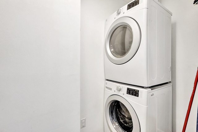 washroom featuring stacked washer and clothes dryer