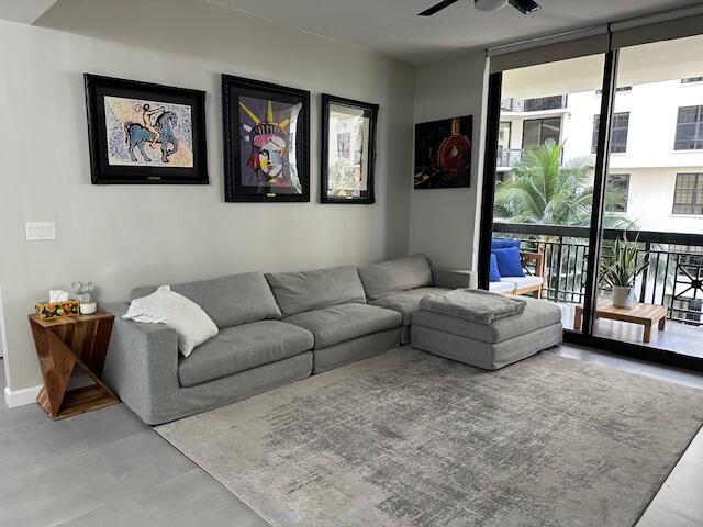 living room featuring ceiling fan and floor to ceiling windows