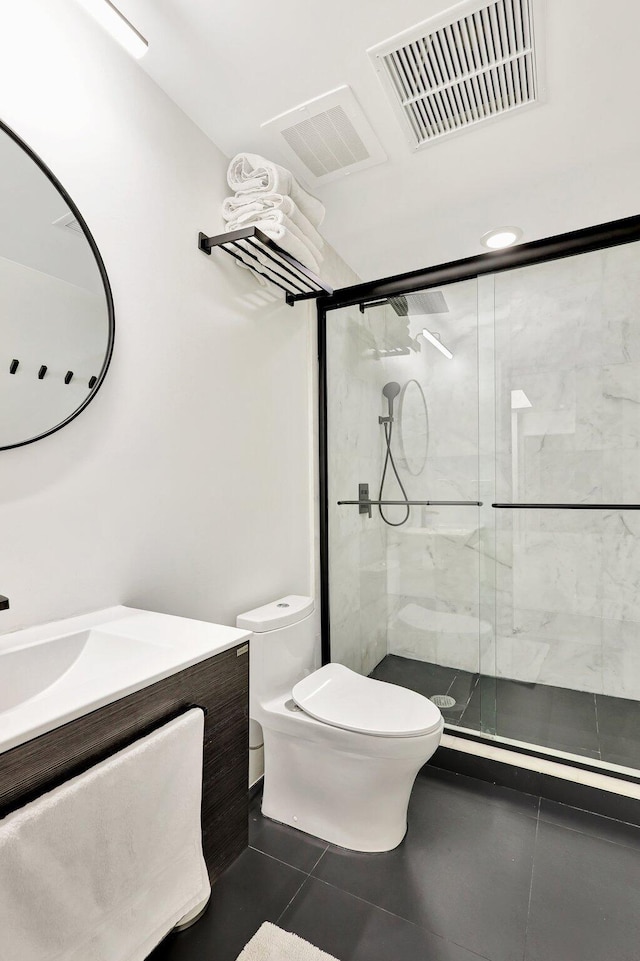 bathroom with toilet, vanity, tile patterned flooring, and a shower with shower door