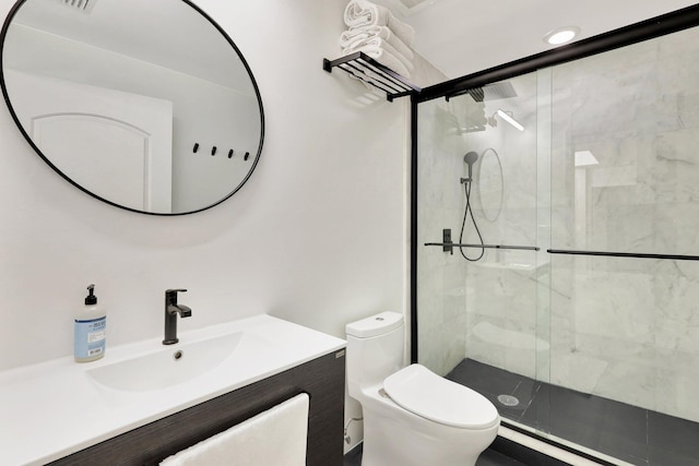 bathroom with vanity, a shower with shower door, and toilet