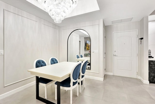 tiled dining room featuring a chandelier