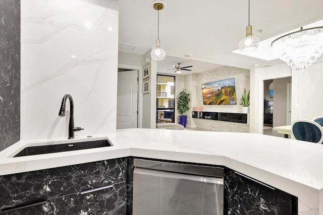 kitchen with hanging light fixtures, light stone countertops, stainless steel dishwasher, ceiling fan, and sink