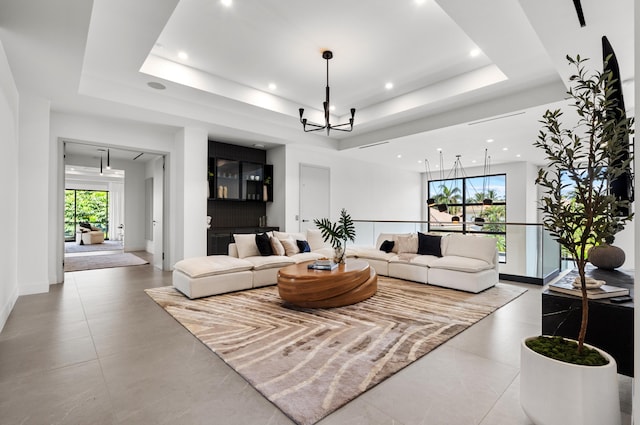 living room with a notable chandelier and a tray ceiling