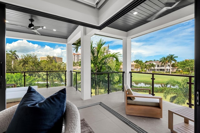 balcony featuring ceiling fan and a water view