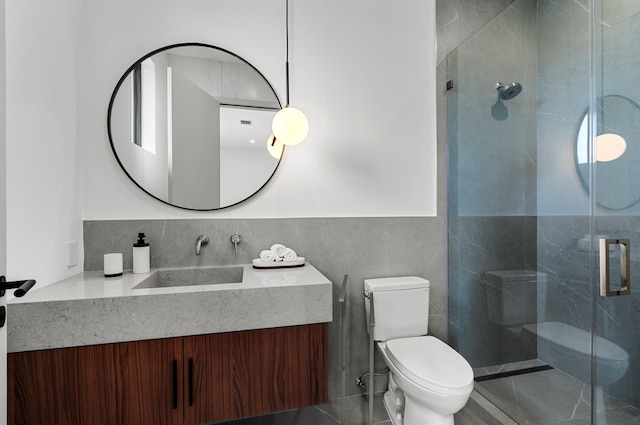 bathroom featuring vanity, tile walls, toilet, and an enclosed shower