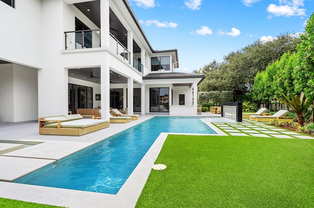 back of house featuring a yard, a balcony, ceiling fan, and a patio area