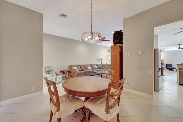 tiled dining space with ceiling fan with notable chandelier