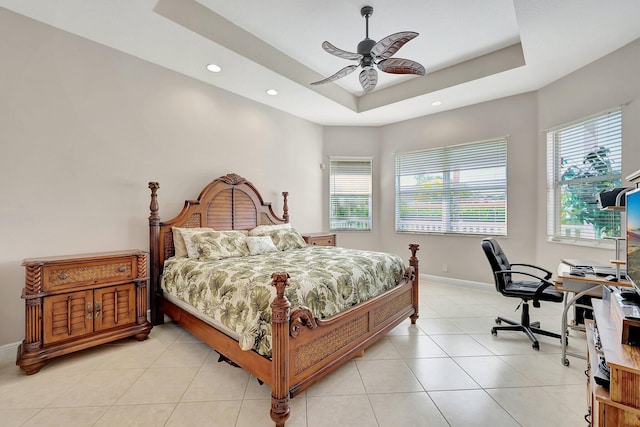 tiled bedroom with a raised ceiling, ceiling fan, and multiple windows