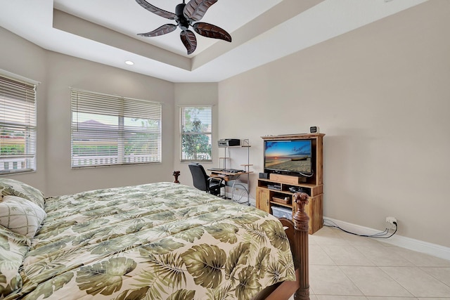 tiled bedroom with a raised ceiling and ceiling fan