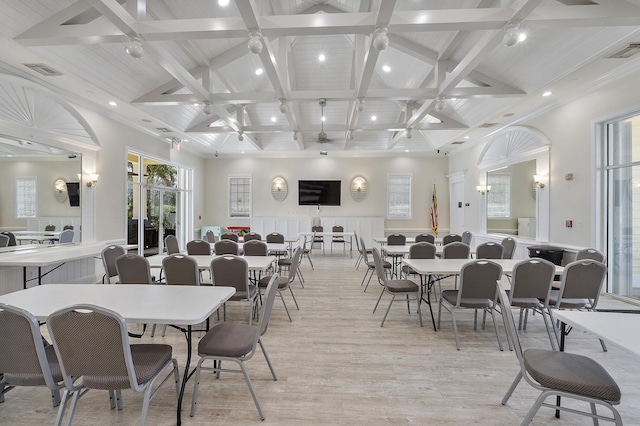 dining space featuring beamed ceiling, high vaulted ceiling, and light wood-type flooring