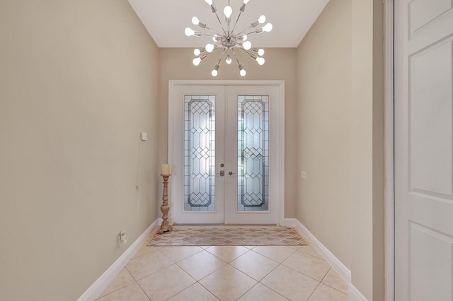 tiled entrance foyer with an inviting chandelier and french doors