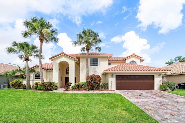 mediterranean / spanish-style house featuring a garage and a front yard