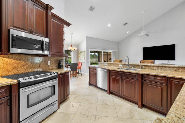 kitchen featuring sink, backsplash, lofted ceiling, and appliances with stainless steel finishes