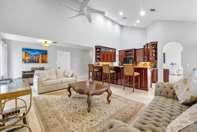 tiled living room featuring a high ceiling and ceiling fan