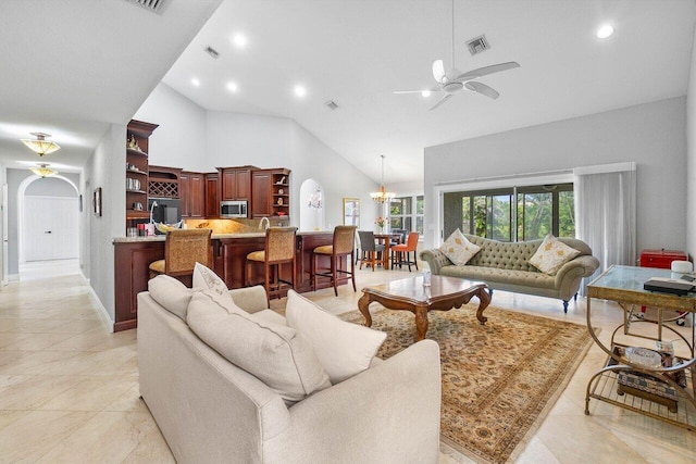 living room featuring ceiling fan with notable chandelier and high vaulted ceiling