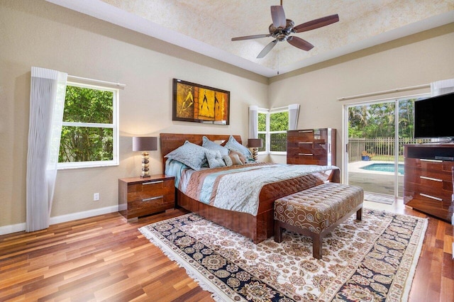 bedroom featuring light wood-type flooring, ceiling fan, access to exterior, and multiple windows