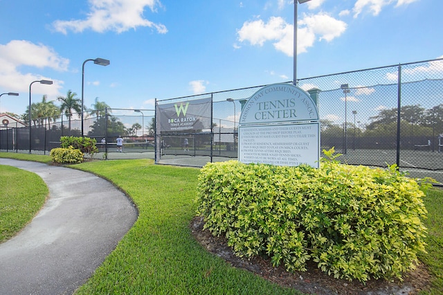 view of property's community featuring tennis court and a yard