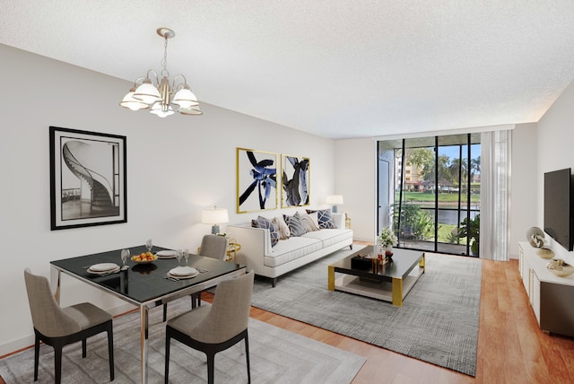 living room featuring a chandelier, a textured ceiling, light hardwood / wood-style flooring, and floor to ceiling windows